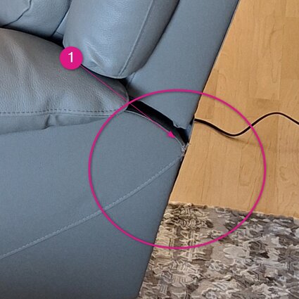 Poškodené relaxačné kreslo s elektrickým polohovaním v sivej farbe, detail na trhlinu v poťahu.