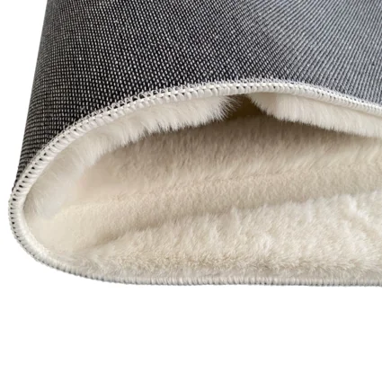 Detail krémového koberca s 3D vzorom, ukazujúci vnútornú štruktúru a materiál.