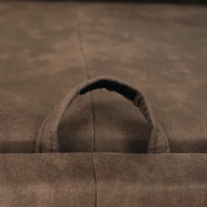 Detail hnedého poťahu sedacej súpravy s úchytkou.