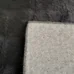Detail koberca v čiernej farbe s bublinkovým vzorom, ukazujúci textúru a okraj koberca.