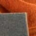 Detail koberca s tehlovou farbou a 3D vzorom, zobrazenie okraja a textúry materiálu.